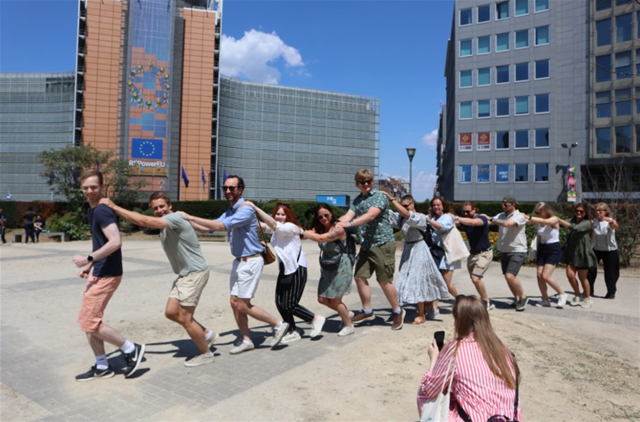 Traineer i Brussel, på rad å rekke danser i en conga line